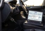Tester VCDS Hex V2 conectat la portul OBD2 cu softul VCDS ROJ 25.3 deschis pe laptop în interiorul unui VW Golf